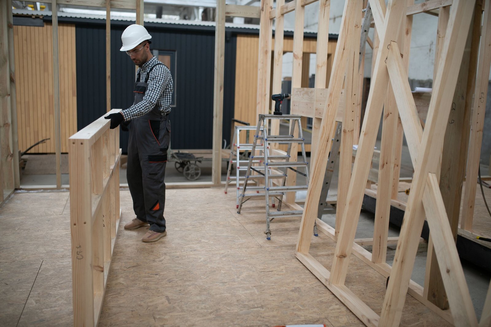Worker carpenter assembling a modular house.